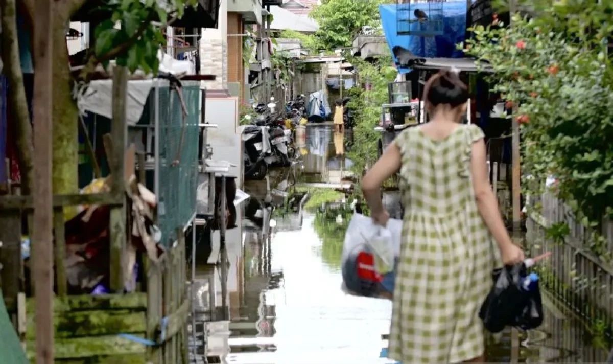 Salah satu warga beraktivitas di tengah genangan air banjir akibat curah hujan yang tinggi di Banjarmasin Selatan, Banjarmasin, Kalimantan Selatan, Kamis (16/1).