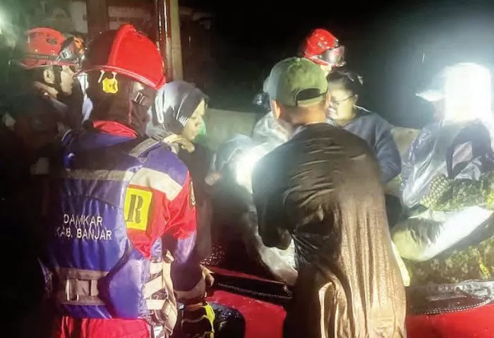 Petugas DPKP Kabupaten Banjar mengevakuasi warga Komplek Green Arena Megatama, di Desa Labuan Tabu, Kecamatan Martapura pada Minggu (26/1) malam