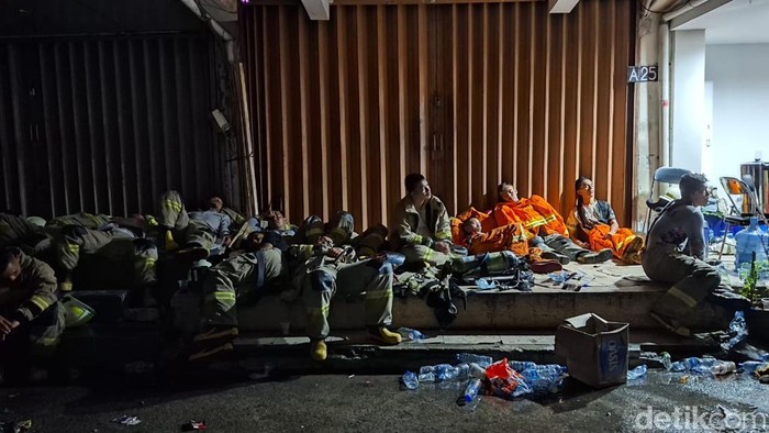 Foto: Petugas damkar beristirahat usai berjam-jam padamkan api di Glodok Plaza.