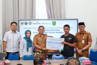 Kepala Dinas PMD Tanah Bumbu, Syamsir, menyerahkan santunan BPJS Ketenagakerjaan sebesar Rp231 juta kepada ahli waris almarhumah Halimatus Sa’diah dalam kegiatan sosialisasi program jaminan sosial ketenagakerjaan di Kecamatan Kusan Tengah, Senin (14/7/2024). Turut hadir Kepala BPJS Ketenagakerjaan Batulicin, Vina Dwina Yuskin, dan camat setempat.