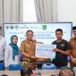 Kepala Dinas PMD Tanah Bumbu, Syamsir, menyerahkan santunan BPJS Ketenagakerjaan sebesar Rp231 juta kepada ahli waris almarhumah Halimatus Sa’diah dalam kegiatan sosialisasi program jaminan sosial ketenagakerjaan di Kecamatan Kusan Tengah, Senin (14/7/2024). Turut hadir Kepala BPJS Ketenagakerjaan Batulicin, Vina Dwina Yuskin, dan camat setempat.