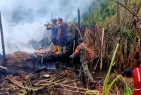 Petugas gabungan dari Damkar Kusan Hilir, Pos Damkar Angsana, TNI, dan relawan berupaya memadamkan sisa api dan melakukan pendinginan di lokasi kebakaran rumah warga di Desa Manurung, Kecamatan Kusan Hilir, Tanah Bumbu, Selasa (15/7/2025).