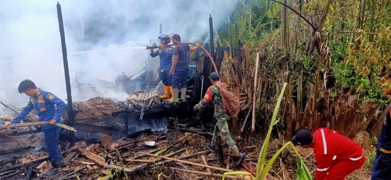 Petugas gabungan dari Damkar Kusan Hilir, Pos Damkar Angsana, TNI, dan relawan berupaya memadamkan sisa api dan melakukan pendinginan di lokasi kebakaran rumah warga di Desa Manurung, Kecamatan Kusan Hilir, Tanah Bumbu, Selasa (15/7/2025).