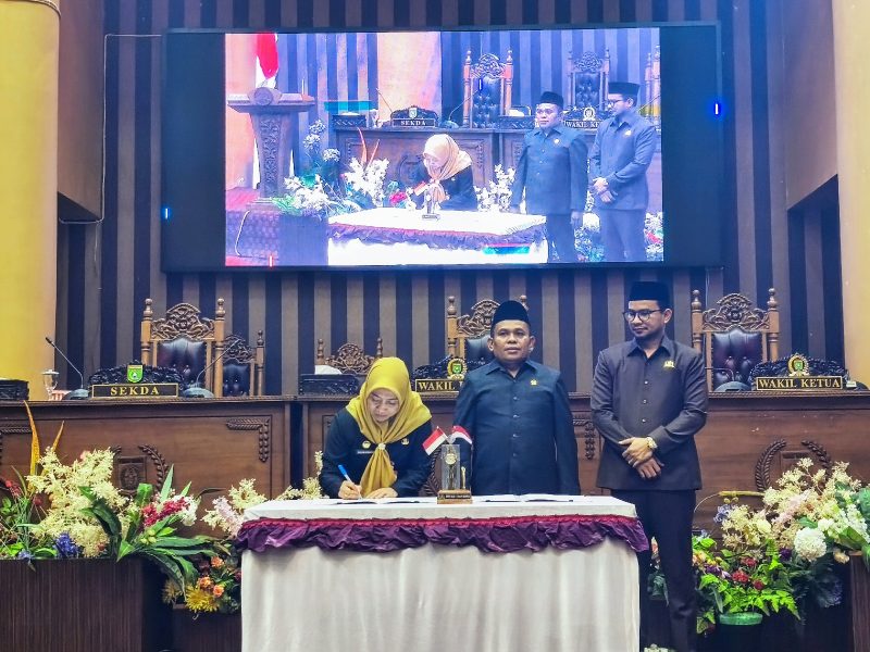 Pj. Sekda Tanah Bumbu, Yulian Herawati, menandatangani naskah Perda disaksikan pimpinan DPRD Tanah Bumbu pada Rapat Paripurna pengesahan tiga Perda baru, Senin (4/8/2025).