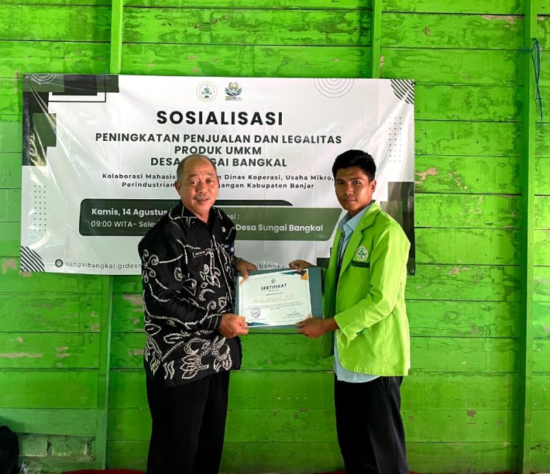 Ketua Kelompok KKN Desa Sungai Bangkal, Ikhsan Abdullah (kanan), menyerahkan sertifikat kepada Kepala Bidang Usaha Mikro DKUMPP Kabupaten Banjar, Rudy Mulyadi, usai sosialisasi peningkatan penjualan dan legalitas produk UMKM di Desa Sungai Bangkal, Kamis (14/8/2025).