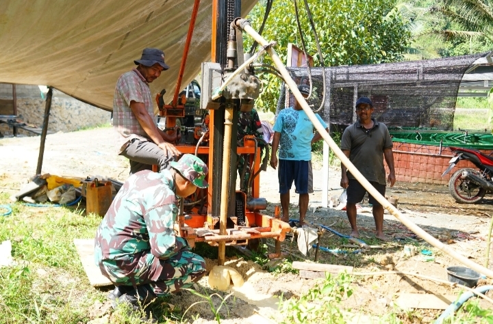 Anggota Satgas TMMD ke-126 Kodim 1022/Tanah Bumbu bersama warga Desa Mantewe bergotong royong melakukan pengeboran sumur dalam program TNI Manunggal Air Bersih.