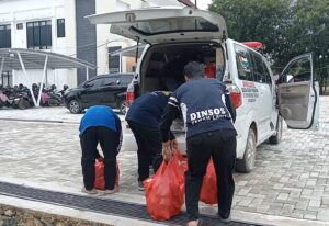 Petugas Dinsos Tanah Laut memuat paket bantuan pangan ke dalam ambulans untuk didistribusikan ke wilayah terdampak banjir.