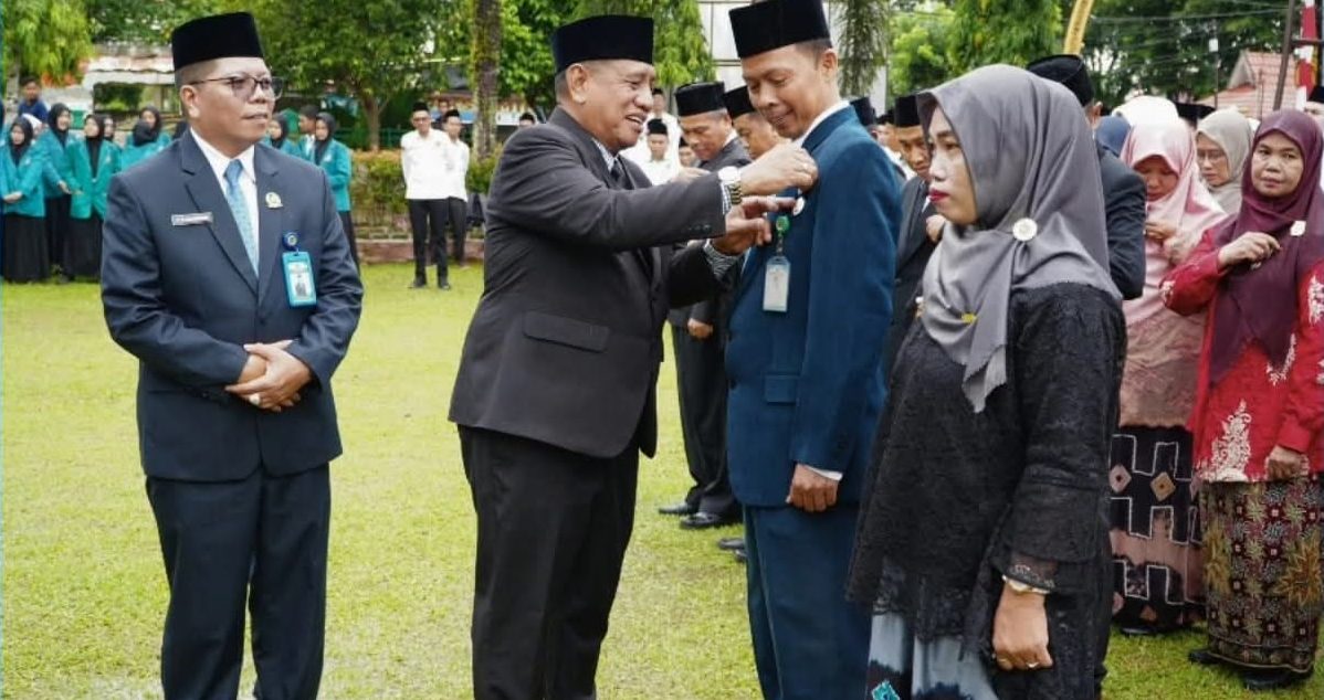 HM Zazuli menyematkan tanda kehormatan Satyalancana Karya Satya kepada aparatur Kementerian Agama pada peringatan HAB ke-80 di halaman Kantor Kemenag Tanah Laut, Sabtu (03/01/2026).