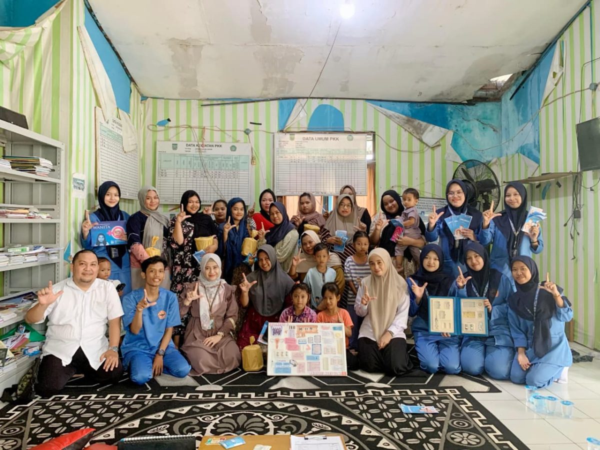 Mahasiswa Profesi Ners ULM Angkatan XXV berfoto bersama dosen pembimbing, tim penyuluh KB Kecamatan Karang Intan, serta warga usai kegiatan penyuluhan Keluarga Berencana (KB) di Balai Desa Sungai Asam, Kabupaten Banjar.