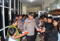 Wakapolres Tanah Bumbu didampingi personel saat membagikan paket takjil kepada penumpang Kapal Awu-Awu di area pelabuhan.
