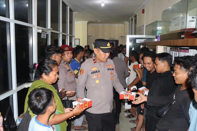 Wakapolres Tanah Bumbu didampingi personel saat membagikan paket takjil kepada penumpang Kapal Awu-Awu di area pelabuhan.