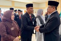 Kepala Kanwil Kementerian Agama Kalimantan Selatan Dr. Muhammad Tambrin menyalami H. Khairun Noor, didampingi istri Hj. Ernawati, S.Sos, usai prosesi pelantikan sebagai Kepala Kantor Kemenag Kabupaten Tanah Bumbu di Aula Harmoni Kanwil Kemenag Kalsel, Senin (16/03/2026). (Istimewa)