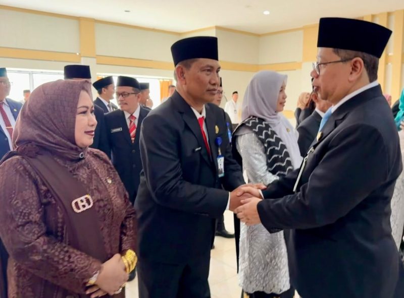 Kepala Kanwil Kementerian Agama Kalimantan Selatan Dr. Muhammad Tambrin menyalami H. Khairun Noor, didampingi istri Hj. Ernawati, S.Sos, usai prosesi pelantikan sebagai Kepala Kantor Kemenag Kabupaten Tanah Bumbu di Aula Harmoni Kanwil Kemenag Kalsel, Senin (16/03/2026). (Istimewa)