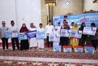 Bupati Tanah Bumbu Andi Rudi Latif (tengah) menyerahkan secara simbolis bantuan sosial kepada masyarakat saat kegiatan Safari Ramadan di Masjid Nurul Hidayah, Desa Rantau Panjang Hilir, Kecamatan Kusan Hilir, Jumat (06/03/2026).