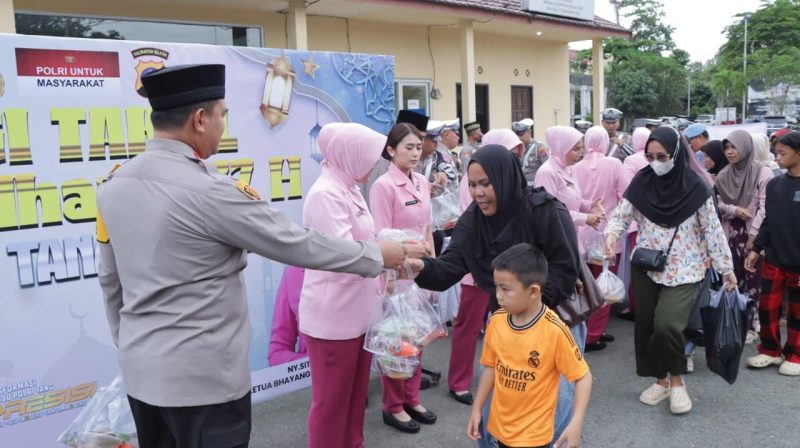 Kapolres Tanah Bumbu AKBP Arief Prasetya bersama jajaran dan Bhayangkari saat membagikan paket takjil kepada pengguna jalan di depan Mako Polres Tanah Bumbu, Kamis (12/3/2026) sore.