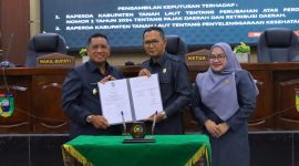 Wakil Bupati Tanah Laut H. M. Zazuli (Kiri) bersama pimpinan DPRD Tanah Laut menunjukkan dokumen persetujuan dua Rancangan Peraturan Daerah (Raperda) usai rapat paripurna pengambilan keputusan di Pelaihari, Kamis (12/03/2026).