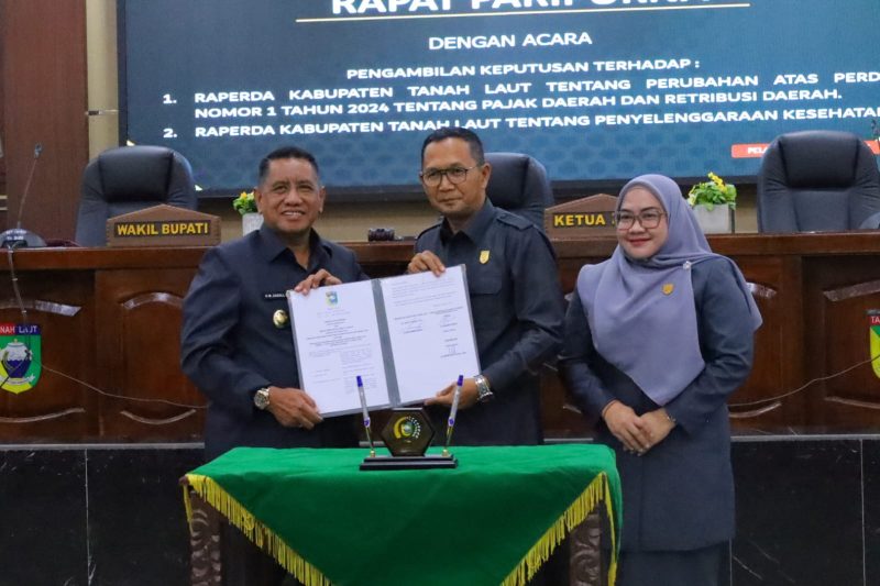 Wakil Bupati Tanah Laut H. M. Zazuli (Kiri) bersama pimpinan DPRD Tanah Laut menunjukkan dokumen persetujuan dua Rancangan Peraturan Daerah (Raperda) usai rapat paripurna pengambilan keputusan di Pelaihari, Kamis (12/03/2026).