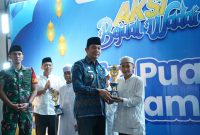 Bupati Tanah Bumbu, Andi Rudi Latif, menyerahkan piala kepada pemenang Lomba Dai Cilik pada penutupan Aksi Bajual Wadai 2026 yang digelar di halaman Masjid Agung Al-Falah, Simpang Empat, Kamis (12/03/2026).