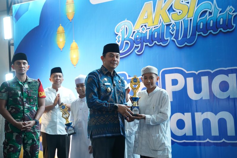 Bupati Tanah Bumbu, Andi Rudi Latif, menyerahkan piala kepada pemenang Lomba Dai Cilik pada penutupan Aksi Bajual Wadai 2026 yang digelar di halaman Masjid Agung Al-Falah, Simpang Empat, Kamis (12/03/2026).