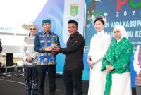 Bupati Tanah Bumbu Andi Rudi Latif menyerahkan secara simbolis bibit Tomat Cherry Stevia kepada perwakilan petani pada pembukaan Aksi Inovasi Tanbu 2026 di Ruang Terbuka Publik, Simpang Empat, Kamis (02/04/2026).