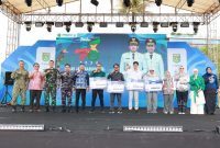 Bupati Tanah Bumbu Andi Rudi Latif bersama jajaran Forkopimda, Ketua Dekranasda, serta para pemenang Lomba Desain Logo HUT ke-23 Tanah Bumbu berfoto bersama usai penyerahan hadiah pada pembukaan Aksi Inovasi Tanbu 2026 di Ruang Terbuka Publik Simpang Empat, Kamis (02/04/2026).