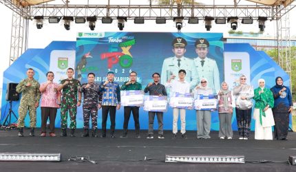 Bupati Tanah Bumbu Andi Rudi Latif bersama jajaran Forkopimda, Ketua Dekranasda, serta para pemenang Lomba Desain Logo HUT ke-23 Tanah Bumbu berfoto bersama usai penyerahan hadiah pada pembukaan Aksi Inovasi Tanbu 2026 di Ruang Terbuka Publik Simpang Empat, Kamis (02/04/2026).