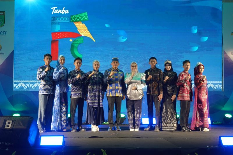 Bupati Tanah Bumbu, Andi Rudi Latif, bersama Ketua Dekranasda Andi Irmayani Rudi Latif berfoto dengan para model usai penampilan koleksi Tenun Pagatan pada Fashion Show Dekranasda dalam rangkaian Aksi Inovasi Tanbu 2026 di Ruang Terbuka Publik Simpang Empat.