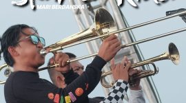 Personel Skamen Rider memainkan alat musik tiup saat tampil membawakan lagu ska dalam sebuah penampilan panggung.