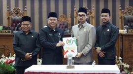 Pimpinan DPRD Tanah Bumbu bersama perwakilan pemerintah daerah menunjukkan dokumen persetujuan saat rapat paripurna pengambilan keputusan pencabutan Perda Nomor 6 Tahun 2020 tentang perubahan status Kelurahan Batulicin, Rabu (06/05/2026).