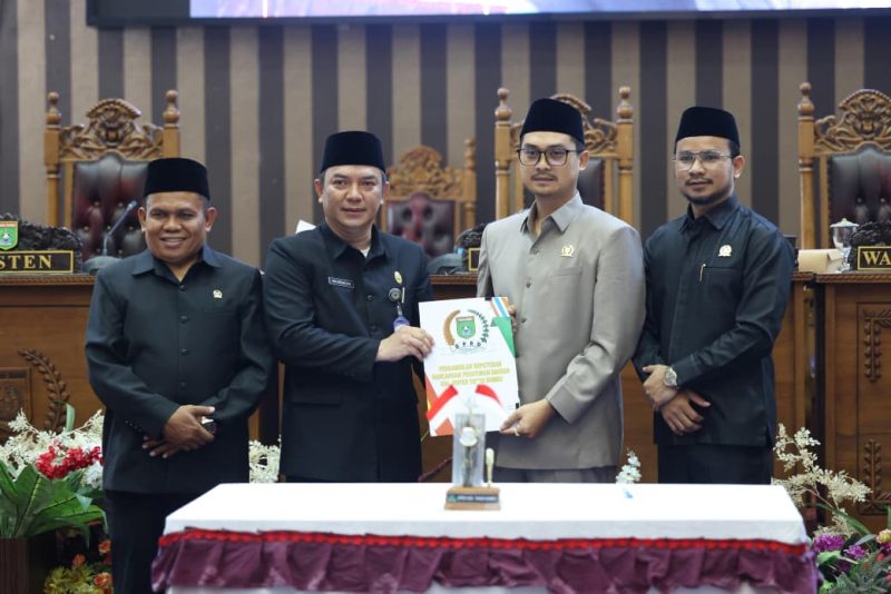 Pimpinan DPRD Tanah Bumbu bersama perwakilan pemerintah daerah menunjukkan dokumen persetujuan saat rapat paripurna pengambilan keputusan pencabutan Perda Nomor 6 Tahun 2020 tentang perubahan status Kelurahan Batulicin, Rabu (06/05/2026).