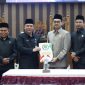 Pimpinan DPRD Tanah Bumbu bersama perwakilan pemerintah daerah menunjukkan dokumen persetujuan saat rapat paripurna pengambilan keputusan pencabutan Perda Nomor 6 Tahun 2020 tentang perubahan status Kelurahan Batulicin, Rabu (06/05/2026).