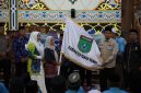 Sekda Tanah Bumbu Yulian Herawati secara simbolis menyerahkan bendera daerah saat pelepasan 239 Jamaah Calon Haji kloter 13 dan 18 asal Kabupaten Tanah Bumbu di Masjid Agung Nurussalam, Batulicin, Kamis (07/05/2026).