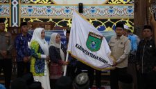 Sekda Tanah Bumbu Yulian Herawati secara simbolis menyerahkan bendera daerah saat pelepasan 239 Jamaah Calon Haji kloter 13 dan 18 asal Kabupaten Tanah Bumbu di Masjid Agung Nurussalam, Batulicin, Kamis (07/05/2026).