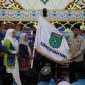 Sekda Tanah Bumbu Yulian Herawati secara simbolis menyerahkan bendera daerah saat pelepasan 239 Jamaah Calon Haji kloter 13 dan 18 asal Kabupaten Tanah Bumbu di Masjid Agung Nurussalam, Batulicin, Kamis (07/05/2026).