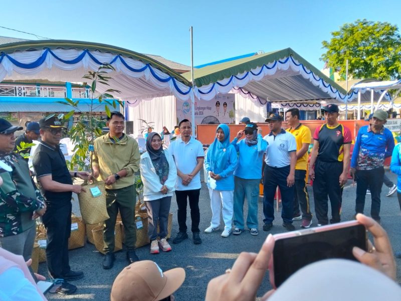 Sekretaris Daerah Kabupaten Tanah Bumbu, Yulian Herawati, didampingi Kepala Dinas Lingkungan Hidup Muhammad Risdianadi dan sejumlah pejabat daerah, menyerahkan bibit pohon buah secara simbolis pada peringatan Hari Lingkungan Hidup Sedunia 2026 di halaman Mal Pelayanan Publik (MPP) Tanah Bumbu, Sabtu (06/06/2026).