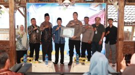 Asisten Perekonomian dan Pembangunan Setda Tanah Bumbu, Eryanto Rais, menyerahkan Sertifikat Penghargaan kepada Kapolres Tanah Bumbu sebagai bentuk apresiasi Pemerintah Kabupaten Tanah Bumbu atas inovasi pelayanan publik Kopi Manis (Kantor Polisi Keliling Humanis), usai pembukaan Pelatihan Bahasa Mandarin Tahun 2026, Jumat (12/6/2026).