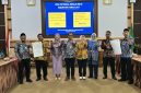 Jajaran KemenPPPA, Pemkab Tanah Laut, camat, dan kepala desa menunjukkan dokumen komitmen pelaksanaan Ruang Bersama Indonesia (RBI) di Aula Bapperida Kabupaten Tanah Laut, Kamis (18/06/2026).