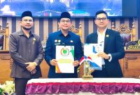 Pimpinan DPRD Tanah Bumbu bersama Bupati Andi Rudi Latif (Tengah) memperlihatkan dokumen usai pengambilan keputusan Rancangan Peraturan Daerah (Raperda) dalam rapat paripurna, Rabu (01/07/2026).