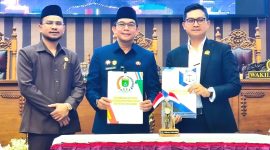 Pimpinan DPRD Tanah Bumbu bersama Bupati Andi Rudi Latif (Tengah) memperlihatkan dokumen usai pengambilan keputusan Rancangan Peraturan Daerah (Raperda) dalam rapat paripurna, Rabu (01/07/2026).