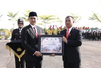 Ketua DPRD Tanah Bumbu Andrean Atma Maulani (kiri) menyerahkan piagam penghargaan kepada Polres Tanah Bumbu pada momentum Hari Bhayangkara ke-80 di Tanah Bumbu, Rabu (01/07/2026).