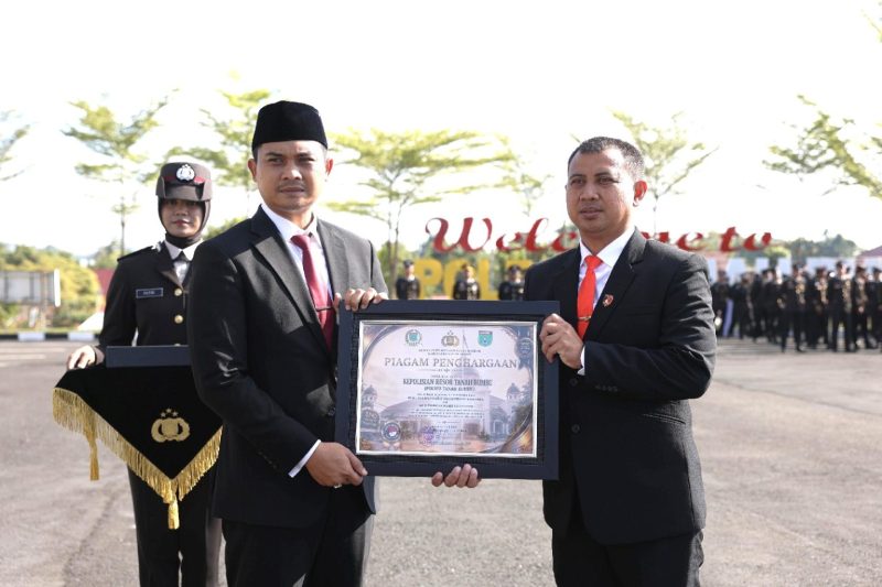 Ketua DPRD Tanah Bumbu Andrean Atma Maulani (kiri) menyerahkan piagam penghargaan kepada Polres Tanah Bumbu pada momentum Hari Bhayangkara ke-80 di Tanah Bumbu, Rabu (01/07/2026).