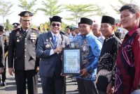 Bupati Tanah Bumbu Andi Rudi Latif menyerahkan piagam penghargaan kepada relawan kemanusiaan pada Apel Gabungan Peringatan Hari Bhayangkara ke-80 di halaman Mapolres Tanah Bumbu, Simpang Empat, Rabu (01/07/2026).