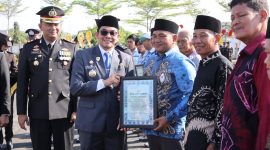 Bupati Tanah Bumbu Andi Rudi Latif menyerahkan piagam penghargaan kepada relawan kemanusiaan pada Apel Gabungan Peringatan Hari Bhayangkara ke-80 di halaman Mapolres Tanah Bumbu, Simpang Empat, Rabu (01/07/2026).