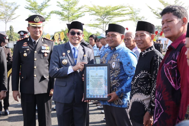 Bupati Tanah Bumbu Andi Rudi Latif menyerahkan piagam penghargaan kepada relawan kemanusiaan pada Apel Gabungan Peringatan Hari Bhayangkara ke-80 di halaman Mapolres Tanah Bumbu, Simpang Empat, Rabu (01/07/2026).