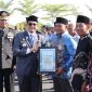 Bupati Tanah Bumbu Andi Rudi Latif menyerahkan piagam penghargaan kepada relawan kemanusiaan pada Apel Gabungan Peringatan Hari Bhayangkara ke-80 di halaman Mapolres Tanah Bumbu, Simpang Empat, Rabu (01/07/2026).