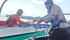 Personel Sat Polairud Polres Kotabaru menyerahkan paket makanan kepada seorang nelayan di perairan Selat Laut dalam kegiatan Jumat Berkah sebagai bentuk kepedulian kepada masyarakat pesisir, Jumat (31/07/2026).