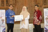 Bupati Tanah Bumbu menyerahkan santunan kepada perwakilan mahasiswa ULM dalam acara penarikan peserta KKN Tematik Lingkungan Hidup ULM Tahun 2026 di Tanah Bumbu.