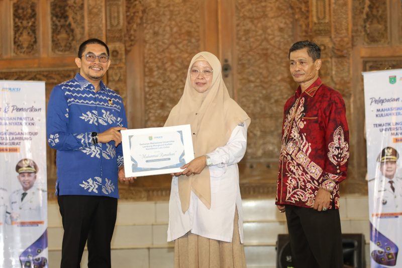Bupati Tanah Bumbu menyerahkan santunan kepada perwakilan mahasiswa ULM dalam acara penarikan peserta KKN Tematik Lingkungan Hidup ULM Tahun 2026 di Tanah Bumbu.