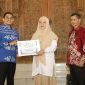 Bupati Tanah Bumbu menyerahkan santunan kepada perwakilan mahasiswa ULM dalam acara penarikan peserta KKN Tematik Lingkungan Hidup ULM Tahun 2026 di Tanah Bumbu.