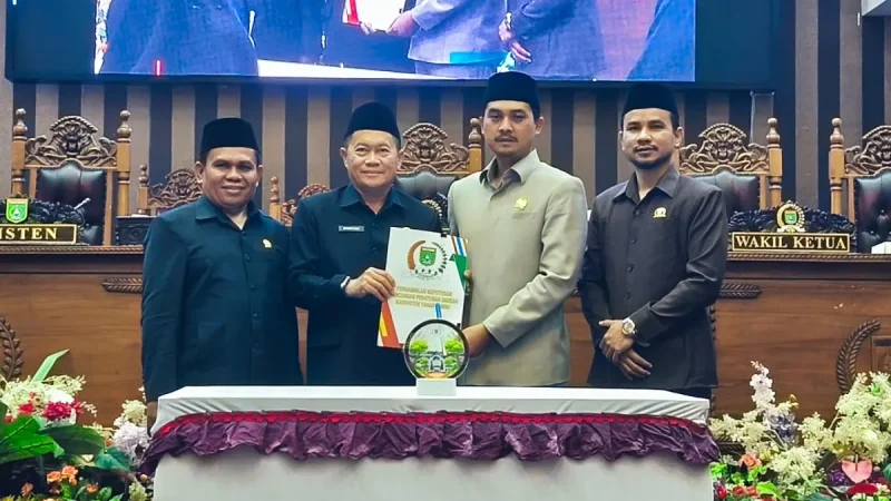Ketua DPRD Tanah Bumbu Andrean Atma Maulani bersama perwakilan  Pemerintah Kabupaten Tanah Bumbu dan pimpinan DPRD menunjukkan dokumen persetujuan tiga Raperda dalam rapat paripurna di Ruang Sidang Utama DPRD Tanah Bumbu, Senin (14/09/2026).